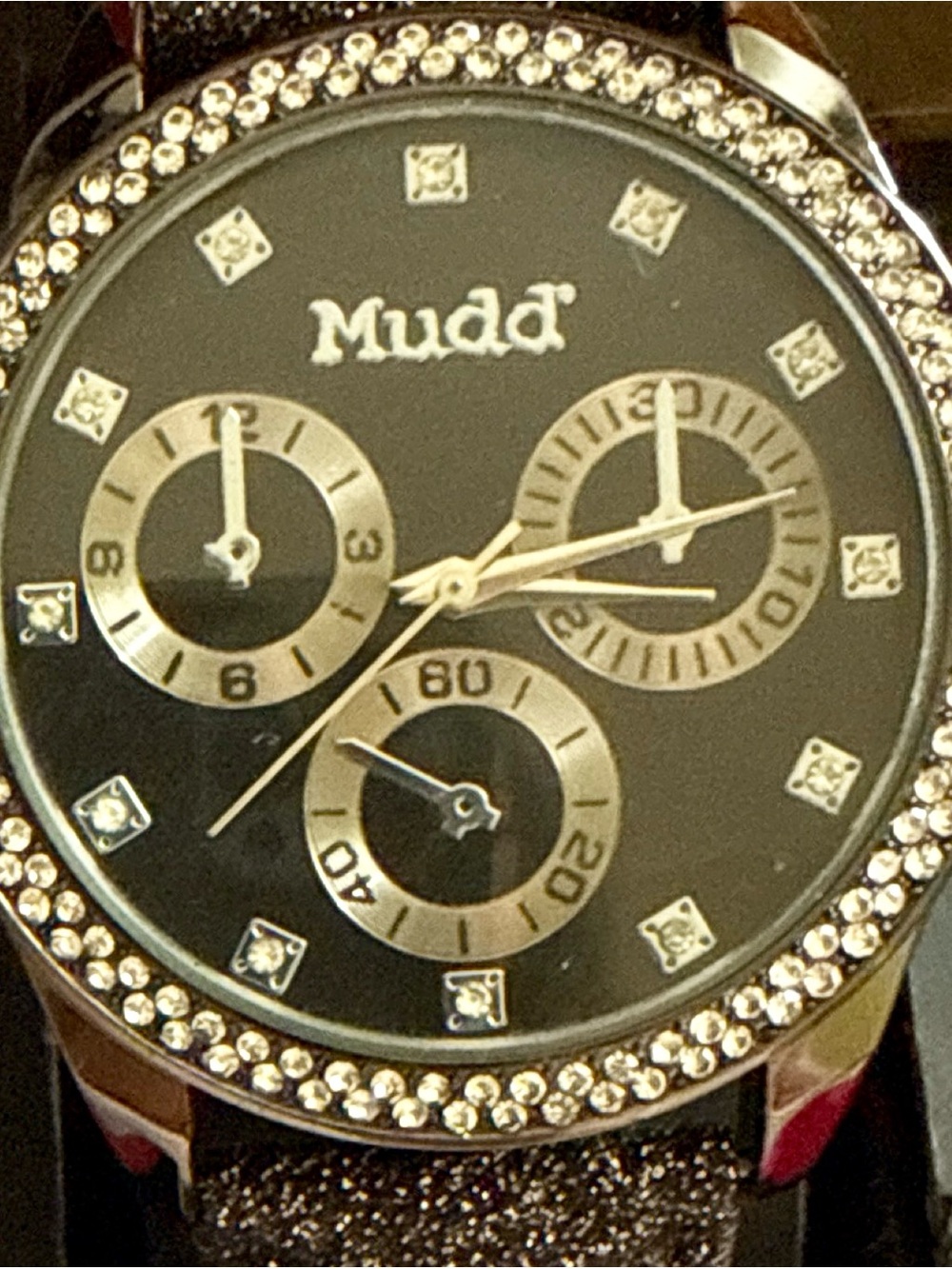 Mudd women's wristwatch-features a sparkling strap & rhinestone-encrusted bezel.